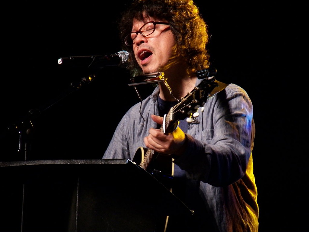 Urasawa tocando una canción de Bob Dylan en la Japan Expo 2012 de París (Foto por Alberto Hernández-CC2.0)